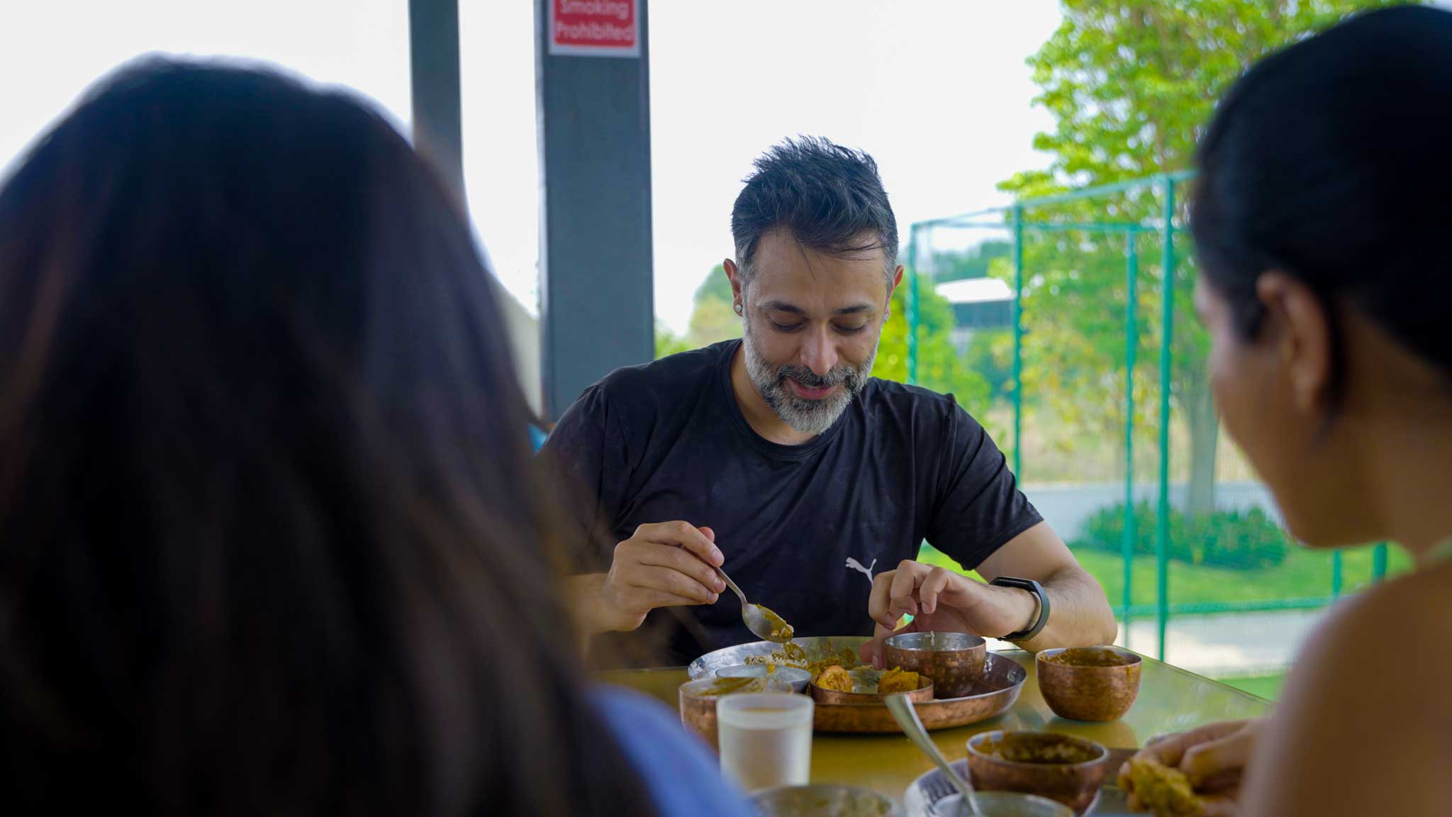 Family enjoying traditional meal together at an outdoor dining area